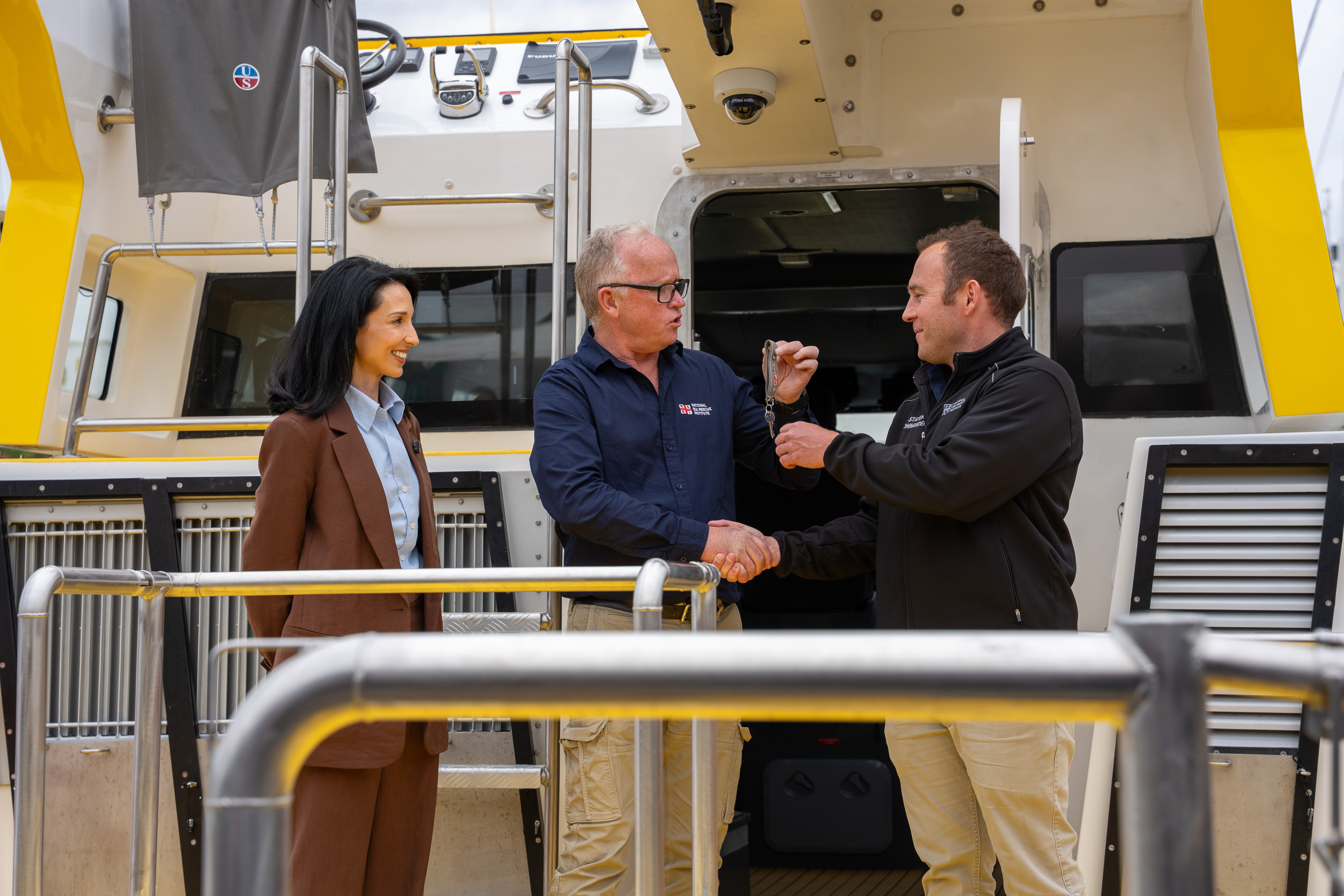 Ilze Bylos, Chief Marketing Officer of the Shoprite Group watches as Graeme Harding, NSRI Head of Fleet and Facilities hands the keys to the Spirit of Shoprite Sixty60 to NSRI Station Cammander Nic Stevens.     Celebrating lives and saving lives as NSRI names Rescue 4 at Mykonos
Personal tributes and a new Shoprite Group sponsorship support lifesaving work on the West Coast

A gift celebrating a couple’s wedding anniversary. A tribute to a mother who quietly supported sea rescue. A husband’s thank you to the wife who helped him through recovery.

These are some of the stories carried by Rescue 4, the National Sea Rescue Institute’s (NSRI) new Offshore Rescue Craft, blessed and named at Club Mykonos, Langebaan, on Saturday 17 October.

Families, donors and volunteers came together to celebrate the vessel, which serves Station 4 Mykonos and the West Coast. Within her RESCUE lettering are the names of loved ones honoured through the NSRI’s Celebrate a Life campaign. Donations made in their honour helped fund her construction.

The vessel was named Spirit of Shoprite Sixty60, recognising a new sponsorship from the Shoprite Group supporting Rescue 4 and the NSRI’s lifesaving work.

For NSRI Chief Executive Officer Mike Vonk, the occasion reflected the many relationships that sustain the organisation.
 Picture Andrew Ingram / NSRI