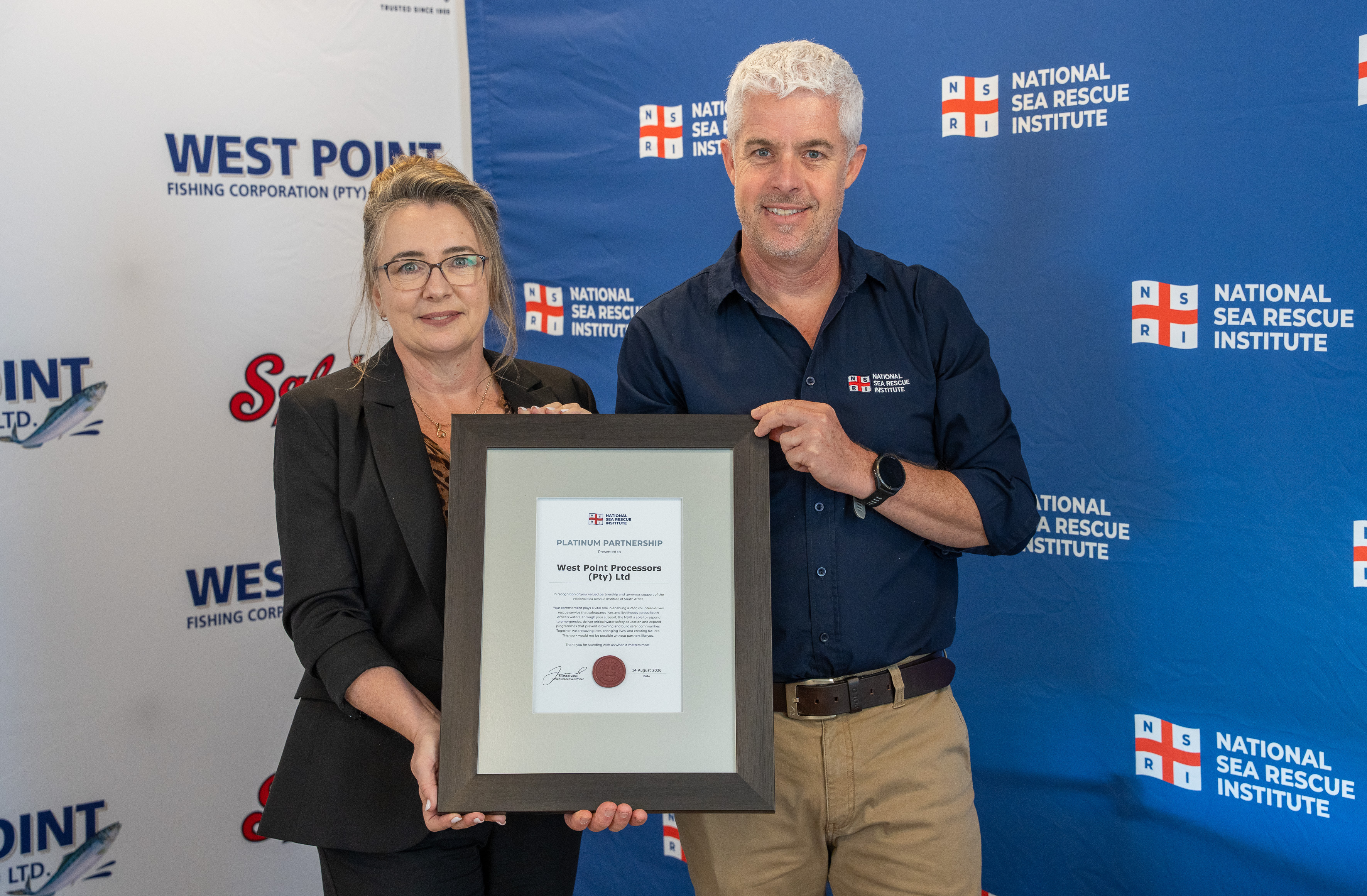 Lynn Boshoff, CEO West Point Processors received West point Processors Platinum certificate from NSRI CEO Mike Vonk. LANGEBAAN – West Point Processors, part of the Sea Harvest Group, has marked 25 years of support for the National Sea Rescue Institute (NSRI) by committing a further R810,000 over the next three years.
The milestone was celebrated at NSRI Station 4 Mykonos on the West Coast, where West Point Processors handed over its R220,000 contribution for 2026 and signed a new three-year Platinum Partnership agreement covering 2027 to 2029. Together, this represents a commitment of more than R1 million to the NSRI over the four-year period.
Picture Andrew Ingram / NSRI